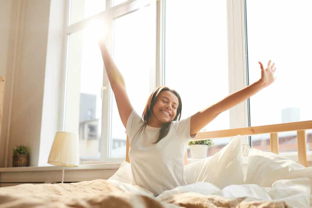 Self care tips for caregivers - a family caregiver waking up after getting a good night’s sleep