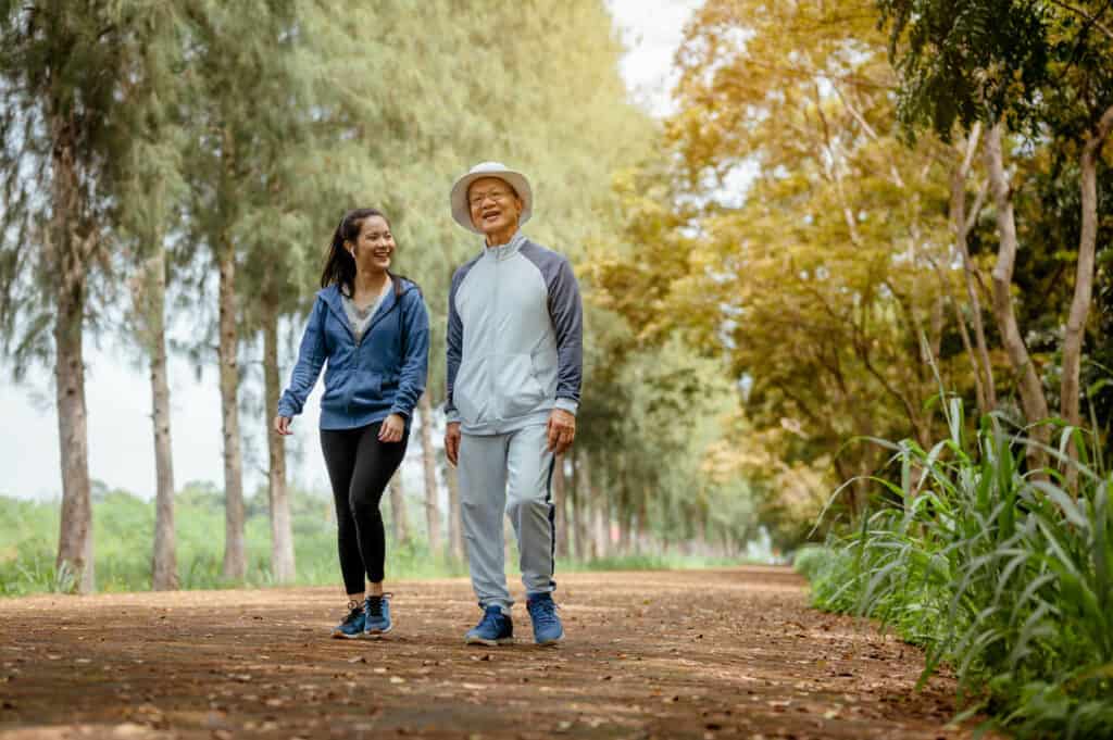 senior gentlemen and a younger woman enjoying brisk walking outdoors | one of the best cardio for seniors