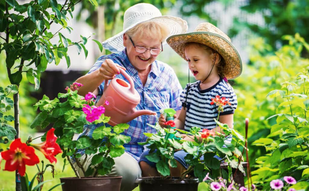 joyful senior woman doing gardening accompanied by a young boy | best aerobic exercise for seniors