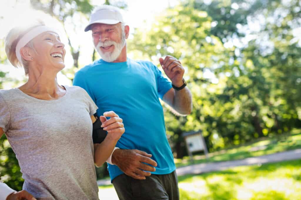 Senior exercise program - a senior couple happily jogging together.