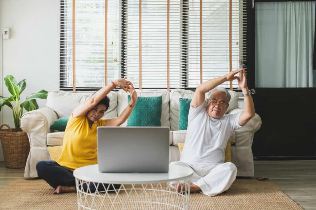 A senior couple doing a senior exercise at home.