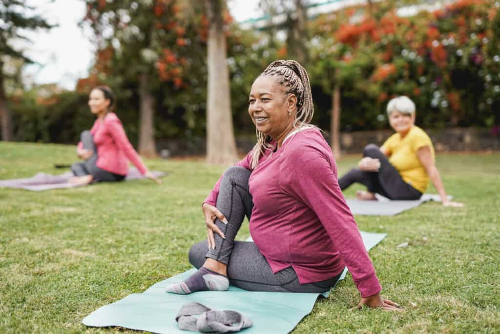 Senior exercise program - a group of older women doing outdoor yoga.