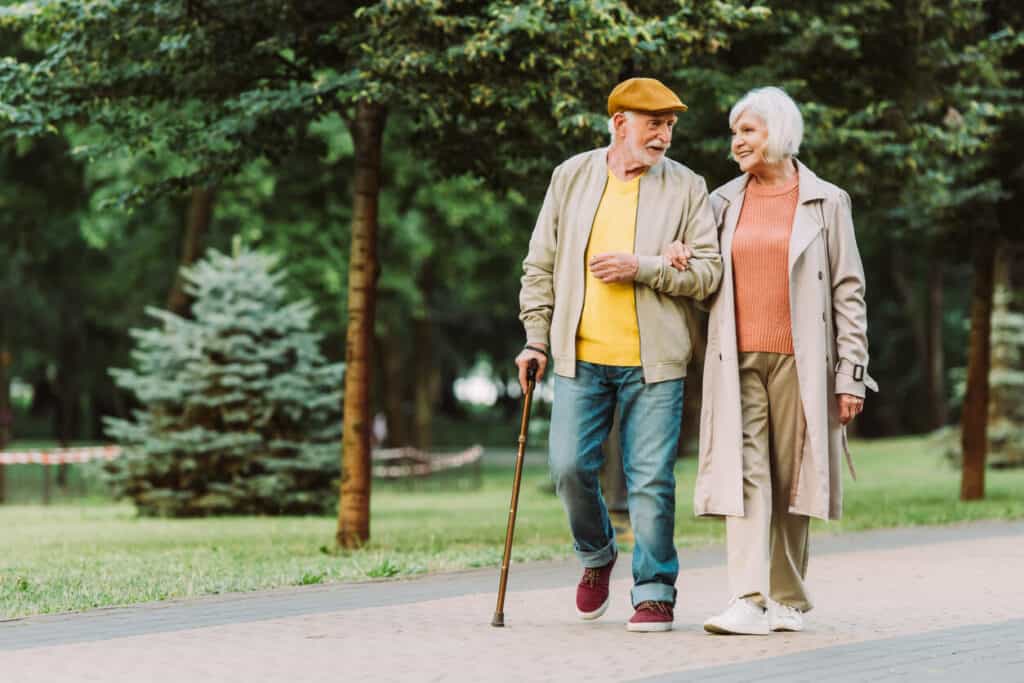Senior exercise routines - a senior couple walking in a park.