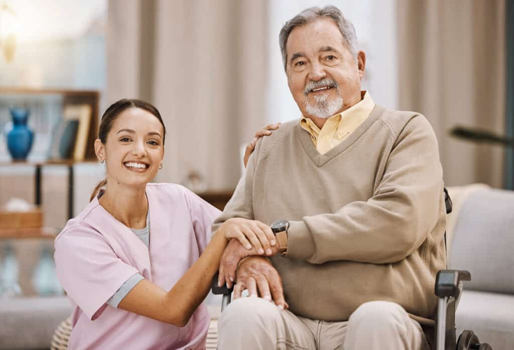 Caregiver fatigue - a smiling and stress-free female caregiver with a disabled senior man in a wheelchair.