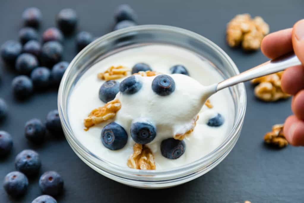 a cup of plain Greek yogurt with added blueberries - two superfoods in one bowl