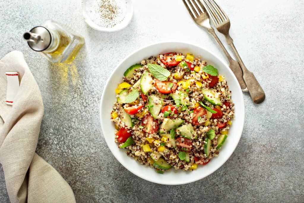 Superfood recipes - a plate of fresh quinoa salad with tomatoes, cucumbers, peppers, and mint