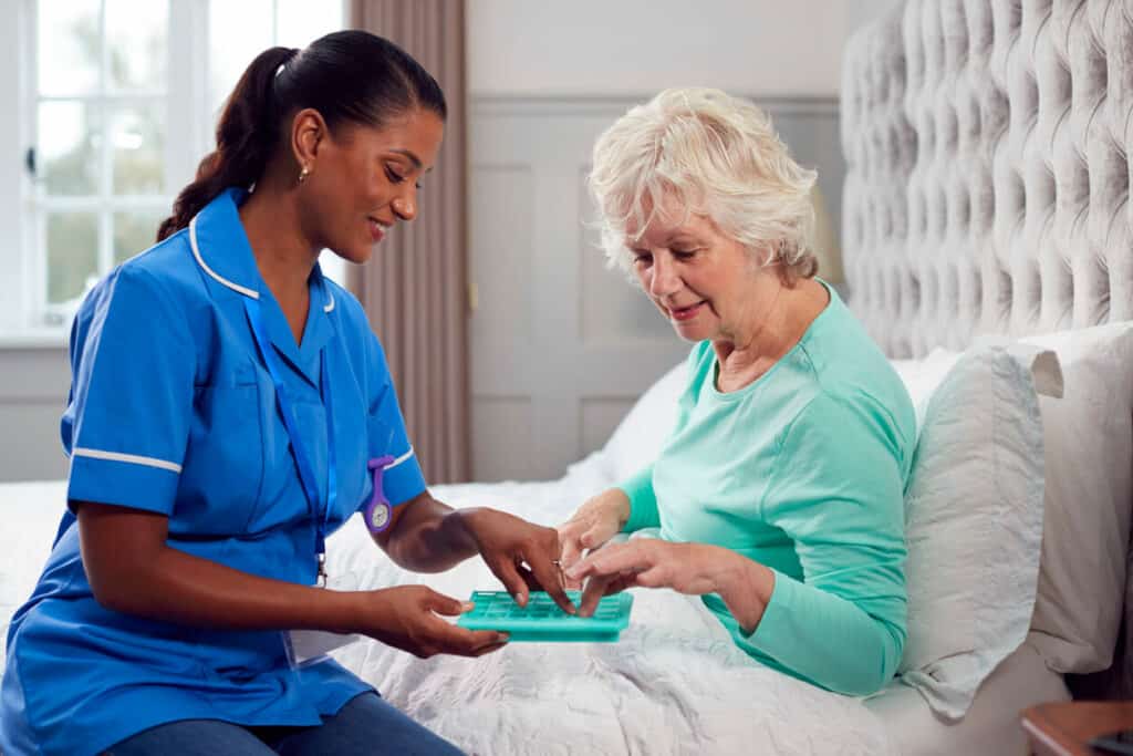 Caregiver helping a senior take her medication - caregiver dementia