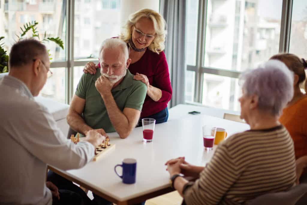 Dementia caregiver support - seniors playing board games and socializing