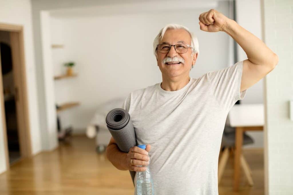 An elderly celebrating his fitness progress - home exercises for elderly