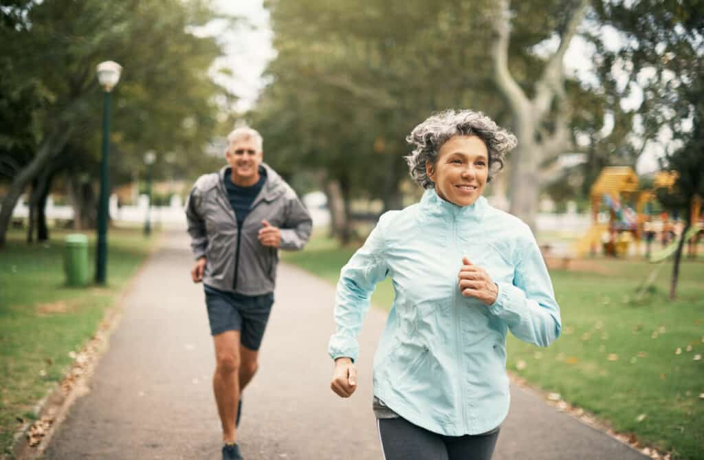 Two elderly people are running in a park - exercises for elderly people