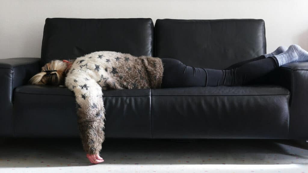 Senior woman is lying on the sofa and lacking motivation for any physical activity - workout for seniors
