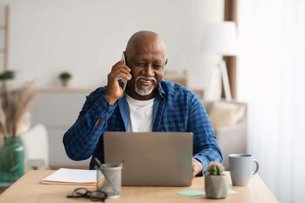 Elderly African-American man talking to a seniors hotline staff member.