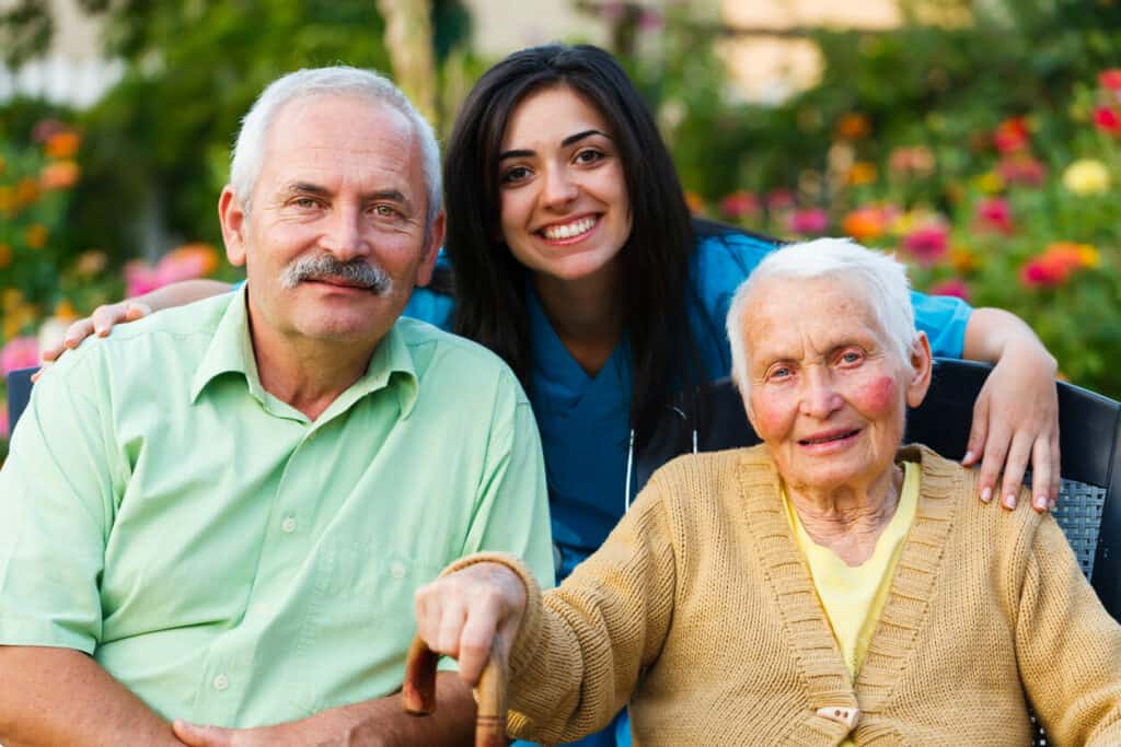 Emotional support for caregivers - a caregiver smiling with a senior man and woman.