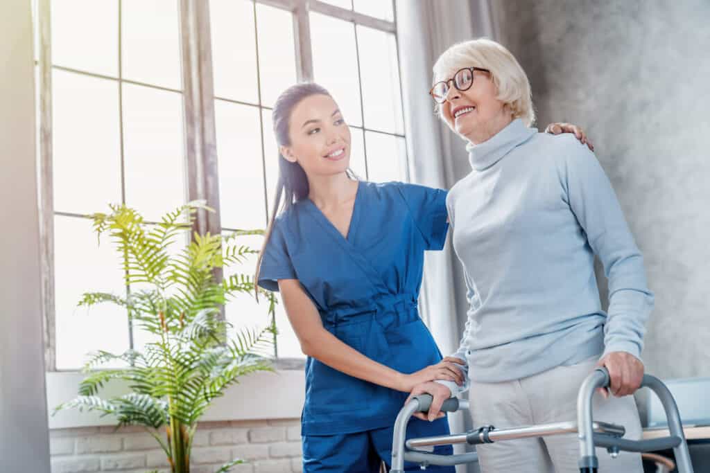 Life as a caregiver - a nurse caregiver assisting a senior woman with difficulty walking.