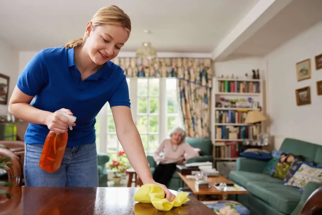 Female personal care assistant doing cleaning at senior’s house - senior home jobs