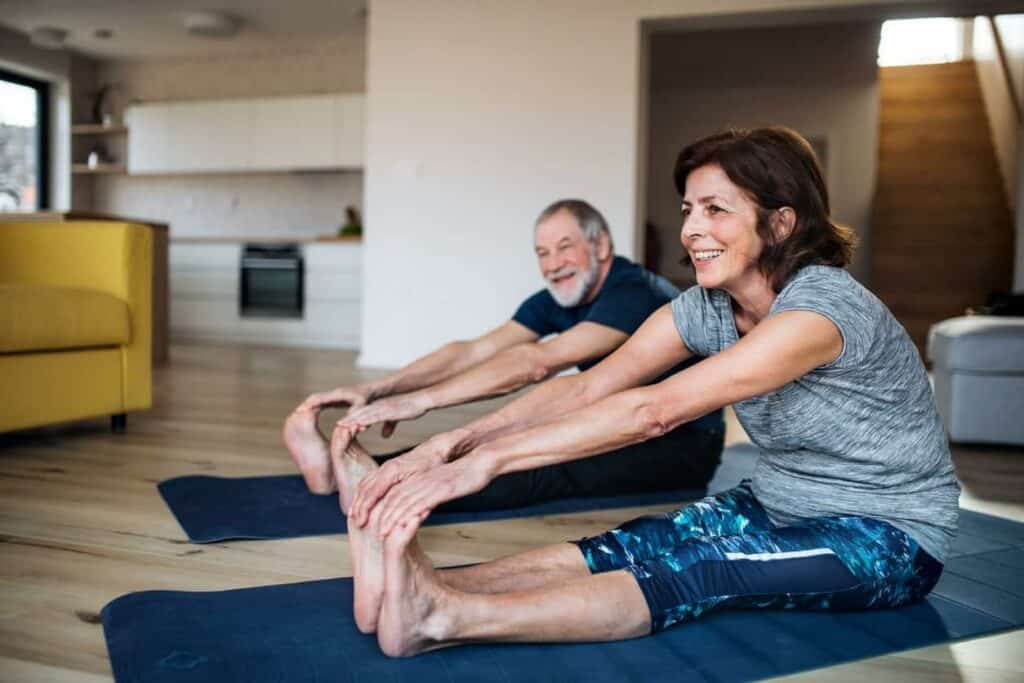 a retired couple having a gentle exercise for seniors at home