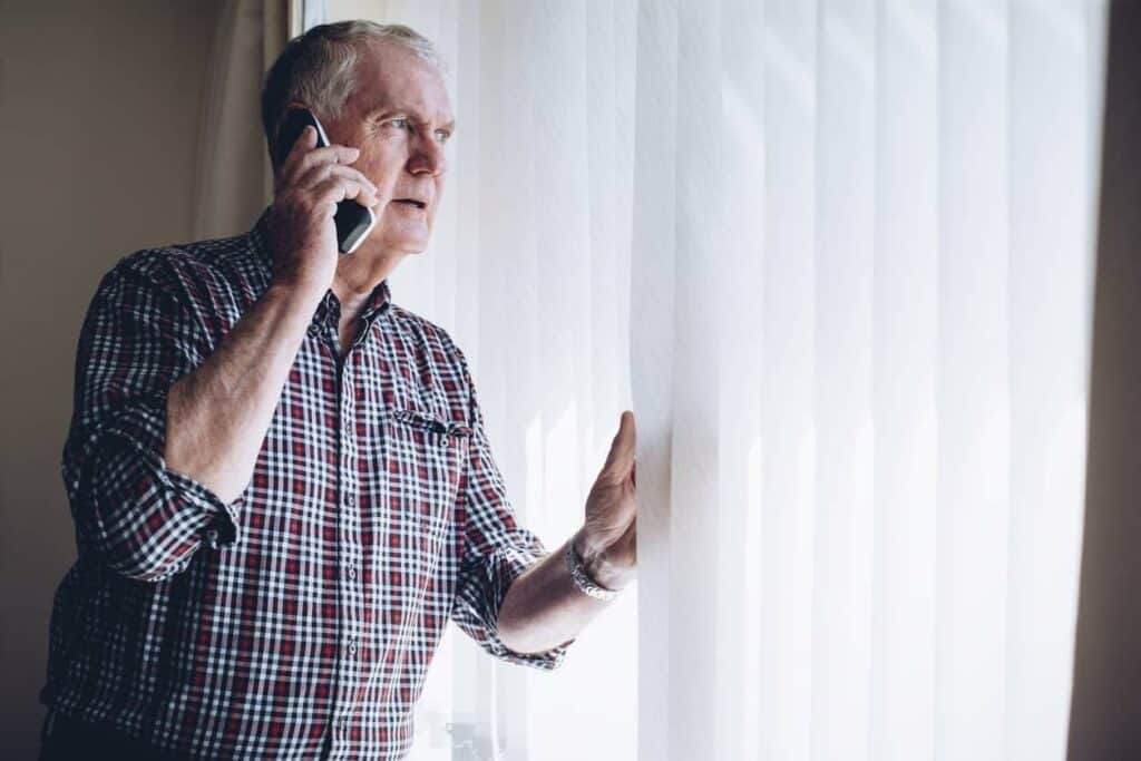 victim of scammer - a senior man reporting a scam on a phone.