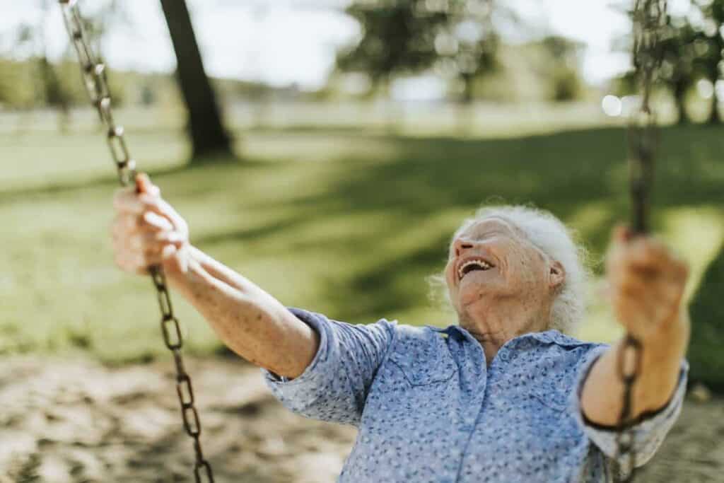 A happy senior woman on a swing in a Carson assisted living.