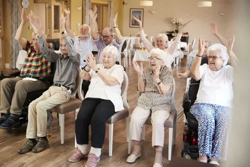 A group of senior residents in a long term care facility doing a fitness program.