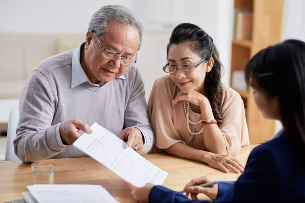 an elderly couple going through seniors 2021 allied fund documents with their daughter