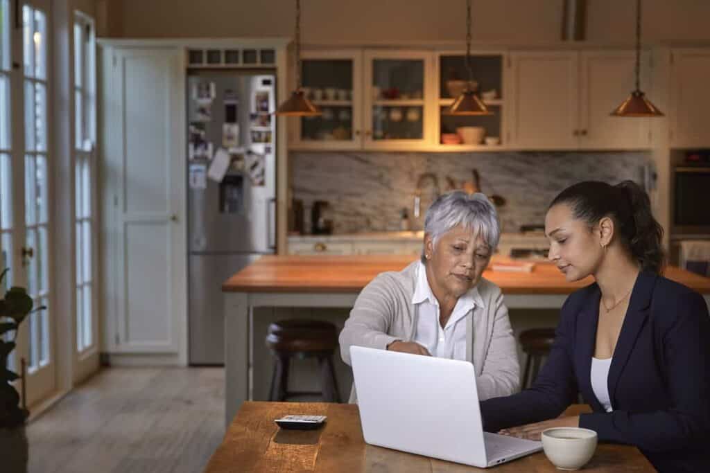 an older woman consulting with her financial advisor at home | seniors 2021 allied fund