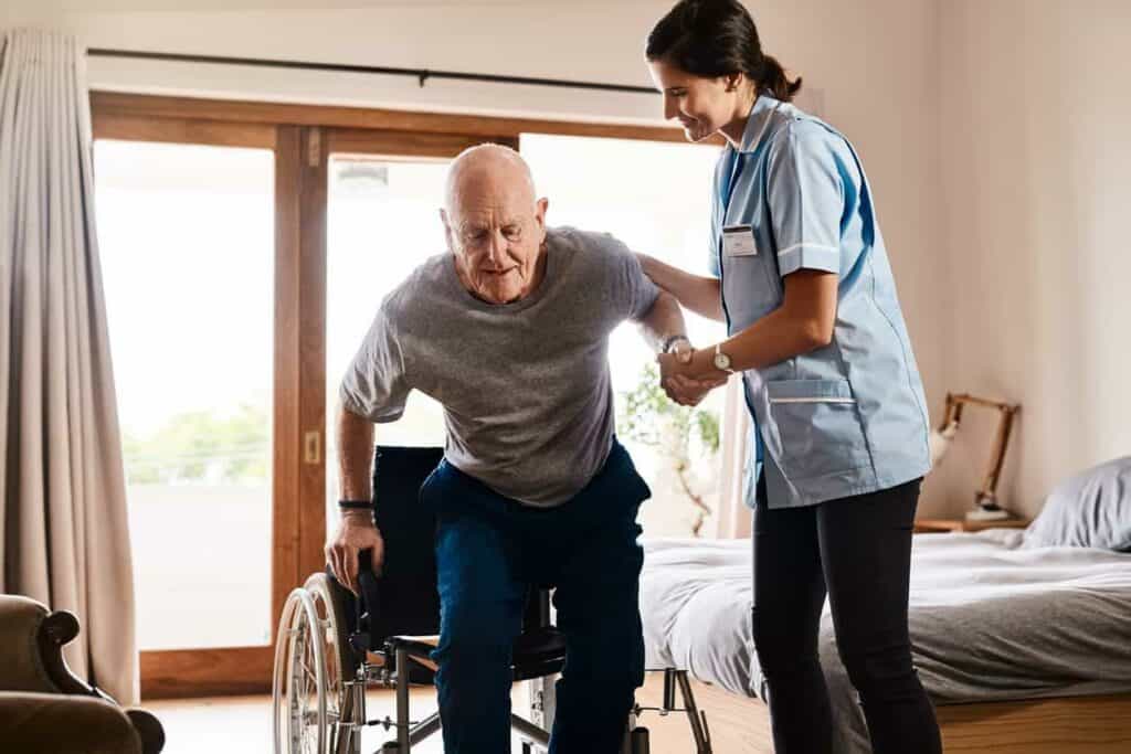 an in-home caregiver helping an elderly from a wheelchair