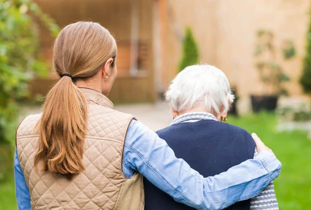 A caregiving walking with an elderly woman - sundowner’s dementia.