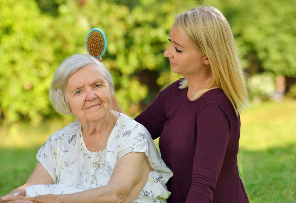 Female caregiver brushing elderly woman’s hair - assisted living Carson City Nevada
