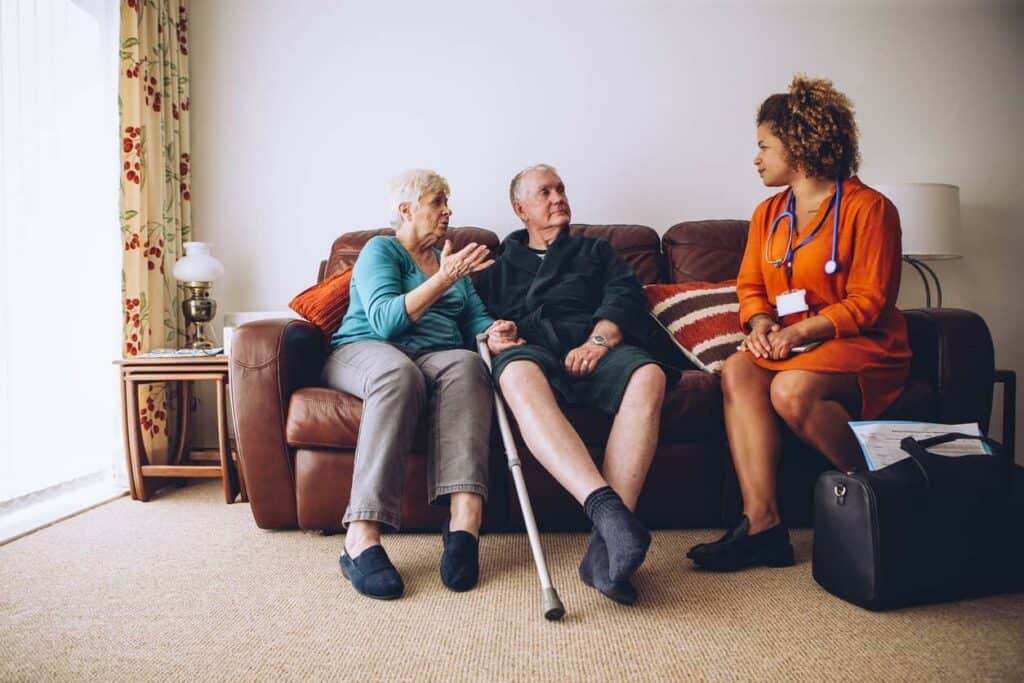 An elderly couple learning about dementia from a care worker - dementia stages.