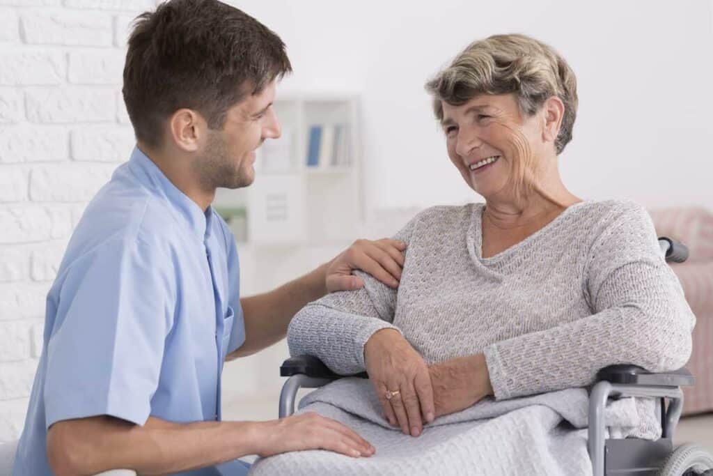 An elderly woman receiving dementia care from a male caregiver - dementia stages.