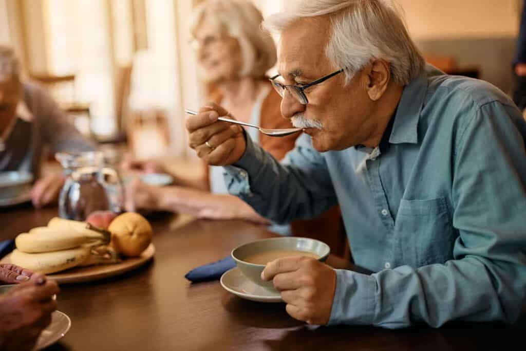 aging adults sharing meal time with fresh food