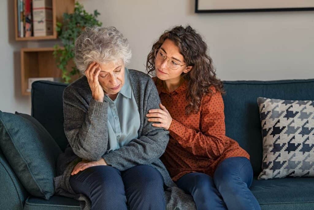 a caregiver comforting an older woman living with sundowner condition