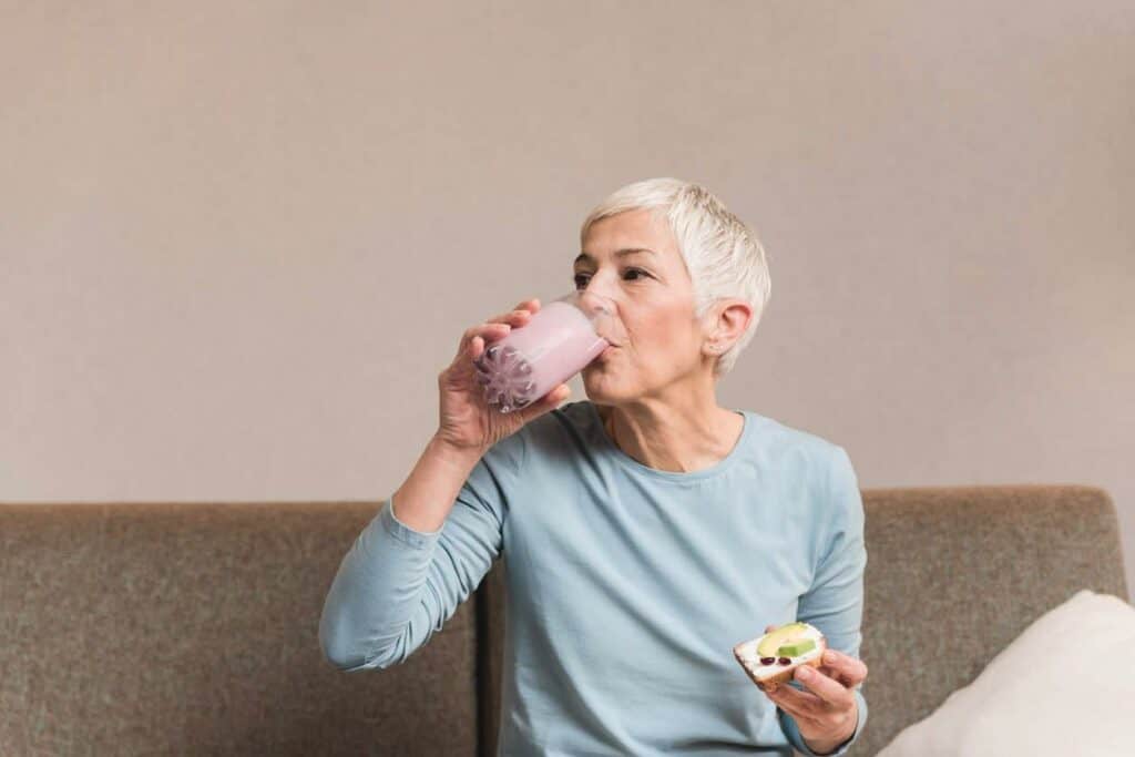 senior woman drinking Ensure energy smoothie