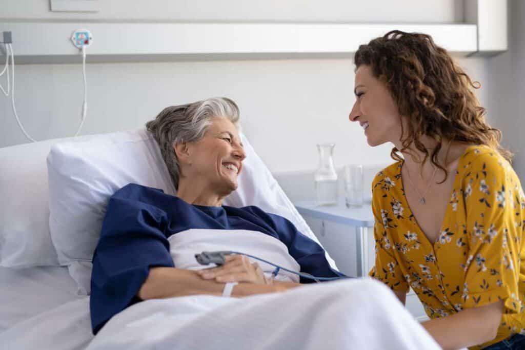 A caregiver discussing electric Hoyer lift cost with a senior woman