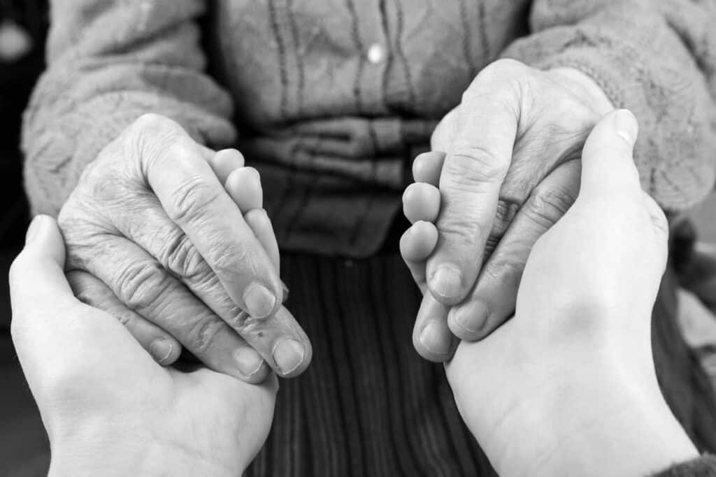 Caregiver holding hands of the elderly in their hands - the stages of dementia