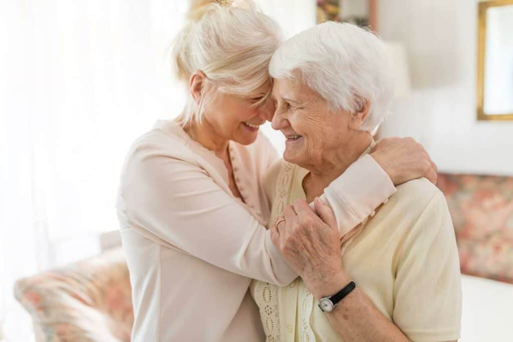 Senior woman and daughter hugging and sharing an affectionate moment | What does assisted living provide?