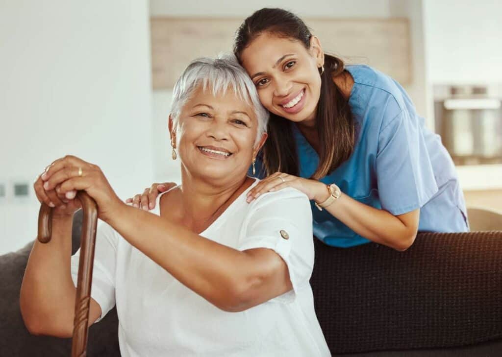 A caregiver smiling with an elderly - home care for elderly