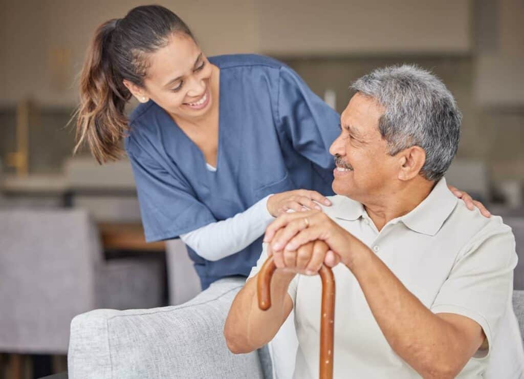 A female nurse smiling with a senior resident - in home health care for seniors.