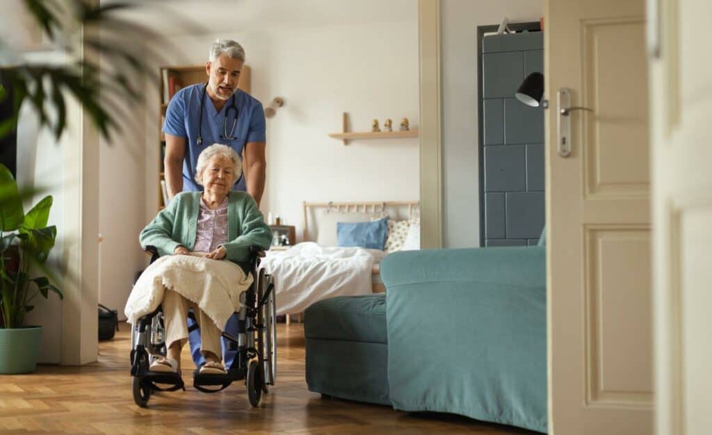 A caregiver helping an older woman with her physical exercises at a nursing home