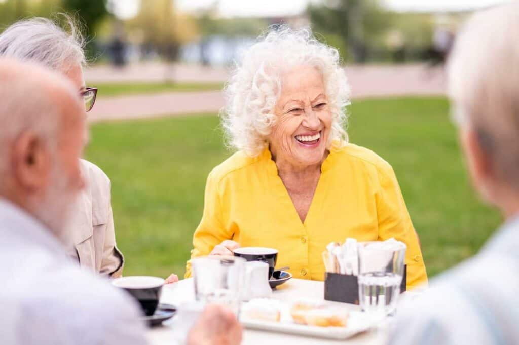assisted living residential home - group of happy residents bonding over a meal | residential assisted living