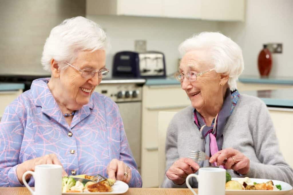 Older adult women complementing their meals with Ensure meal replacement shakes