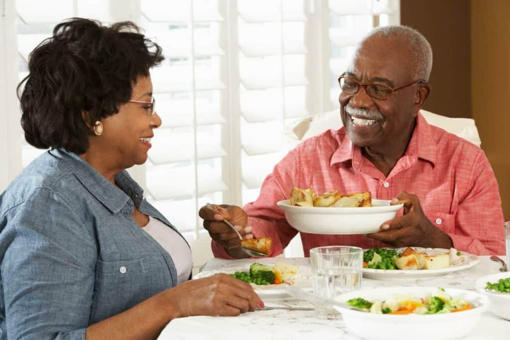 Senior couple enjoying nutritious meal plus ensure dietary drinks at home