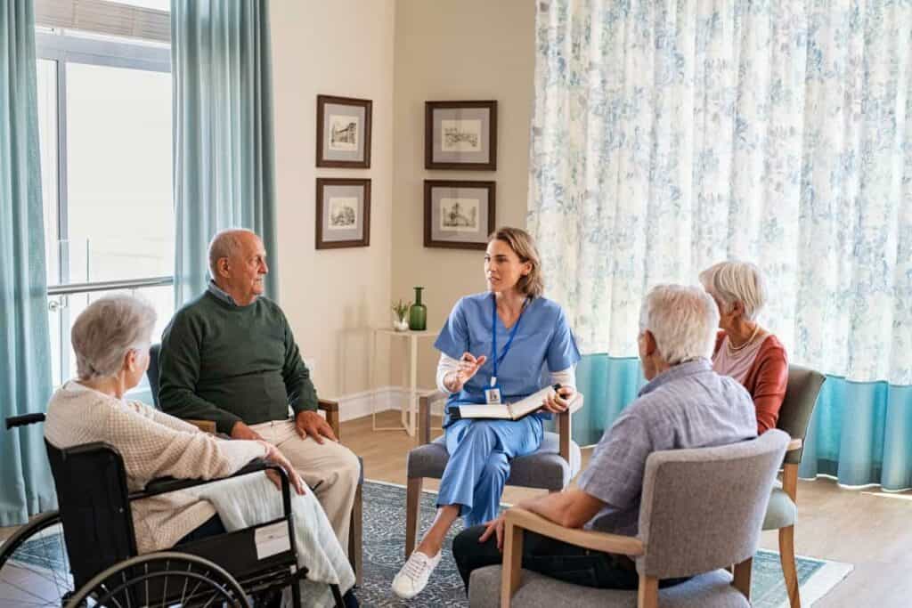 a nurse talking to some couples at a skilled nursing home