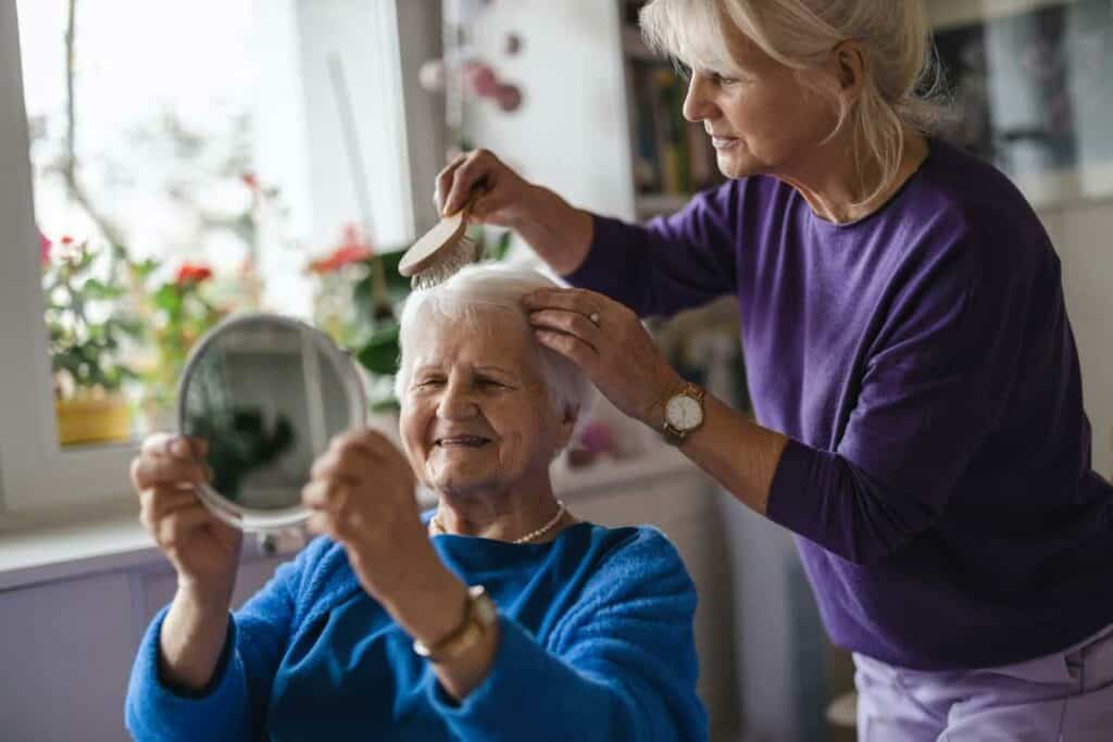 a senior receiving help with her care at an assisted living apartment