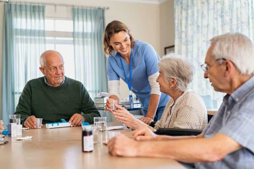 a nurse helping some seniors with their medication at an assisted living apartment