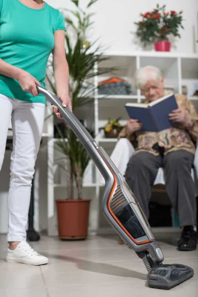 a caregiver helping a senior with their housekeeping at assisted senior living apartments