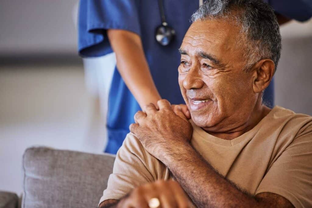 Female caregiver giving support to her elderly patient at home | Typical nursing home room