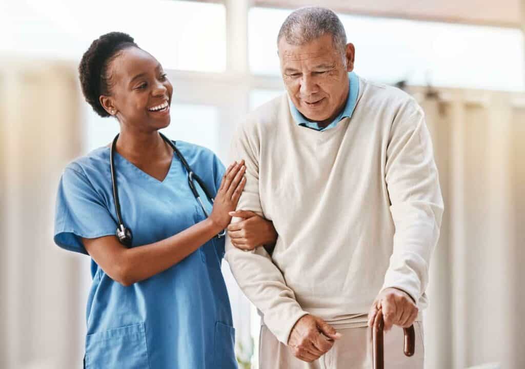 A young nurse helping an older man with walking