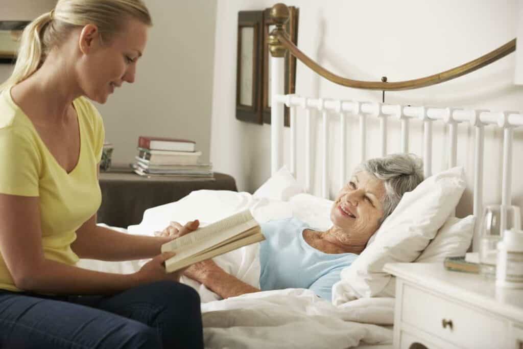 family member reading to an older woman
