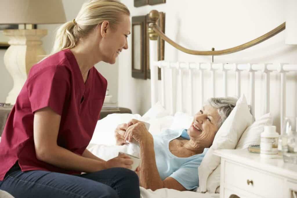 A nurse visiting an ill senior woman at home - palliative care programs.